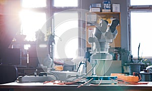 Modern microscope, connectors component and large green microcircuit in workshop laboratory