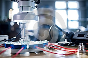 Modern microscope, connectors component and large green microcircuit in workshop laboratory