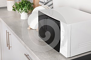 Modern microwave oven on table