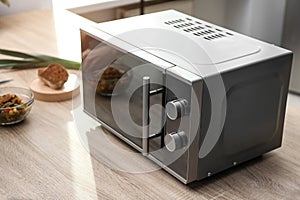 Modern microwave oven on table