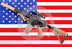 Modern military automatic carbine M4A1 against the background of the American flag. Machine gun on the flag mount.Modern automatic