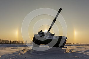 Modern military tank on the background of a solar halo effect. The concept of reducing the world arms race