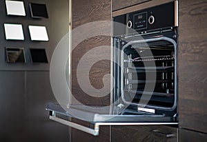 Modern minimal Oven building with wooden furniture in Kitchen with full green tree bokeh glass window beside for copy space