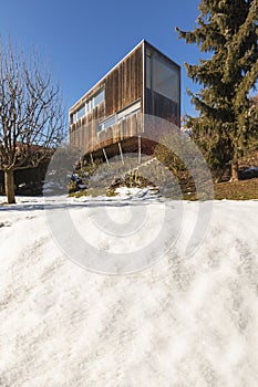 Modern minimal wooden house exterior. The season is winter and therefore you can see the snow in the garden photo