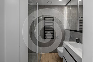Modern minimalist bathroom interior design with grey stone tiles.