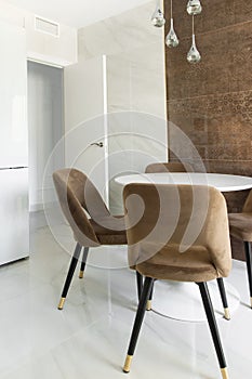 Modern minimalist kitchen interior with brown marble wall chairs around table. Nordic style luxury apartment flat