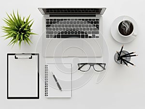 Modern minimalist office desk setup with laptop coffee plant and notebook