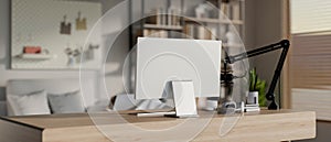 A modern, minimalist radio podcast office featuring a computer, a microphone, and decor