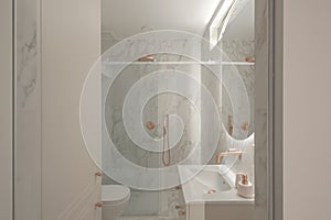 Modern minimalistic bathroom interior design with marble tiles, round mirror with led lighting, copper faucet and shower.