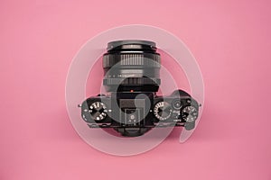 Modern mirrorless camera on a pink background top view. modern technologies in photography. blogger`s accessories