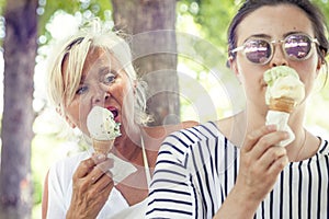 Modern mom and young daughter eating ice cream