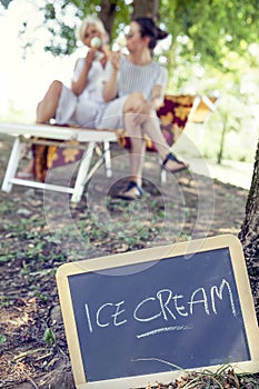 Modern mom and young daughter eating ice cream