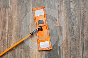 Modern mop on wooden laminated floor at home. Cleaning concept