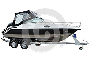 Modern motor boat with canvas top on a trailer for transportation.