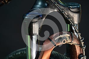 Modern mountain bike in the workshop on a black background. Bike parts close-up, high-quality light in the studio. Cleaning,