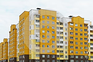 Modern multi-storey house in a new residential complex against the blue sky. The concept of mortgage housing lending and a happy