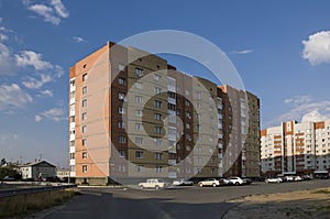 Modern multi-storeyed house with flats. Was built from yellow and orange color