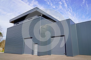 Modern new grey warehouse hangar exterior with gray sectional gate