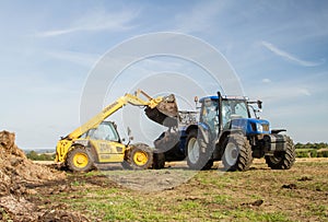 Modern New Holland tractor Tractor spreading manure on fields