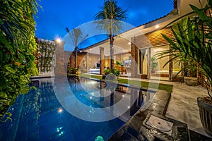 Modern new luxurious mansion exterior with swimming pool and colorful sky at dusk