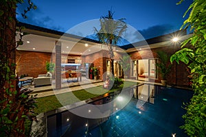 Modern new luxurious mansion exterior with swimming pool and colorful sky at dusk