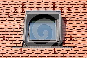 Modern new rectangle roof window with strong metal frame mounted on top of newly built suburban family house