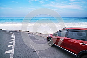 Modern new red SUV car on the road with Summer sea background of free space for summer text and travel transportation background