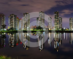 A modern night city with a reflection over the lake