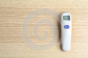 Modern non contact thermometer on table, top view. Space for text