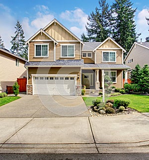 Modern northwest home with tan exterior, and garage.