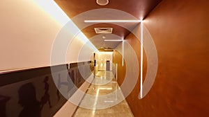 Modern office or building corridor passage with ambient lighting reflective floor and minimalist design moving camera