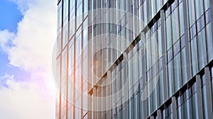 Modern office building detail, glass surface on a clear sky background.