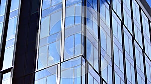 Modern office building detail, glass surface on a clear sky background.