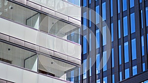 Modern office building detail, glass surface on a clear sky background.