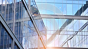 Modern office building detail, glass surface on a clear sky background.