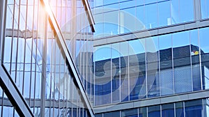 Modern office building detail, glass surface on a clear sky background.