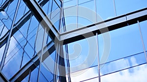 Modern office building detail, glass surface on a clear sky background.