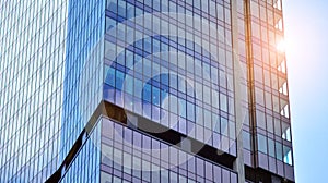 Modern office building detail, glass surface on a clear sky background.