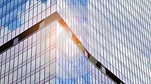 Modern office building detail, glass surface on a clear sky background.