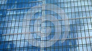 Modern office building detail, glass surface on a clear sky background.