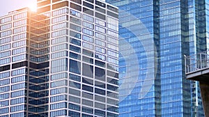 Modern office building detail, glass surface on a clear sky background.