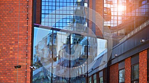 Modern office building detail, glass surface on a clear sky background.