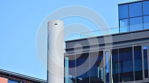 Modern office building detail, glass surface on a clear sky background.