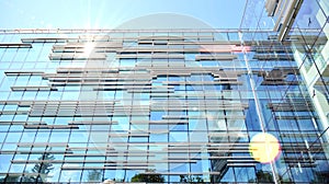 Modern office building detail, glass surface with sunlight