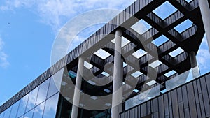 Modern office building exterior with glass facade on clear sky background. Transparent glass wall of office building