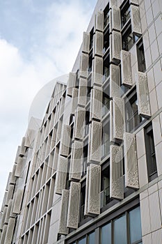 Modern office building exterior with glass facade on clear sky background. Transparent glass wall of office building