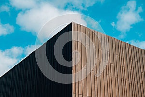 Modern office building exterior with glass facade on clear sky background. Transparent glass wall of office building