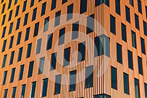 Modern office building exterior with glass facade on clear sky background. Transparent glass wall of office building