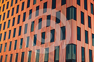 Modern office building exterior with glass facade on clear sky background. Transparent glass wall of office building