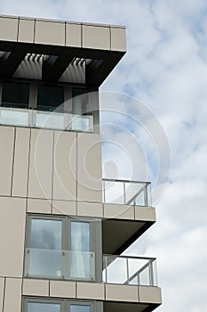 Modern office building exterior with glass facade on clear sky background. Transparent glass wall of office building